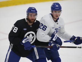 Defenceman T.J. Brodie (left) and forward Jimmy Vesey battle at Maple Leafs practice on Tuesday in preparation for their season opener on Wednesday night against the Montreal Canadiens. The pair are two of the newcomers to Toronto.