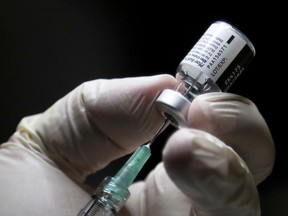 A healthcare worker prepares to administer a Pfizer/BioNTEch coronavirus disease (Covid-19) vaccine at The Michener Institute, in Toronto, Ontario on December 14, 2020.