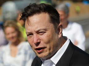 In this Sept. 3, 2020, photo, Tesla CEO Elon Musk talks to media as he arrives to visit the construction site of the future U.S. electric car giant Tesla, on September 3, 2020 in Gruenheide near Berlin.