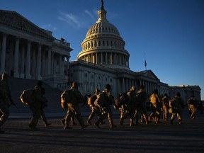 Members of the US National Guard walk past the US Capitol on January 19, 2021 in Washington, DC, ahead of the 59th inaugural ceremony for President-elect Joe Biden and Vice President-elect Kamala Harris.