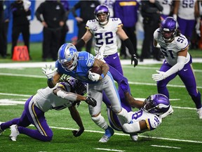 Detroit Lions wide receiver Marvin Jones (11) is tackled by Minnesota Vikings free safety Anthony Harris (41) and cornerback Dylan Mabin (39) during the fourth quarter at Ford Field on Jan. 3, 2021.