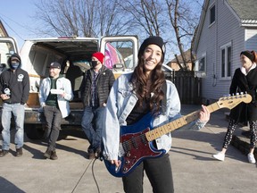 From left, Bryan Datoc, from Craft Heads Brewing, Tom Lucier, from Phog Lounge, and Ian Phillips from Meteor, are joined by singer Tiffany Budway as she performs for Amber Dayus outside her home in Tecumseh, Thursday, Dec. 31, 2020.
