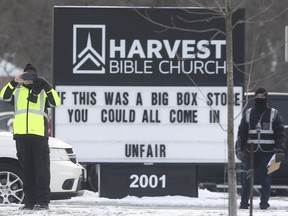 A member of the Harvest Bible Church in Windsor snaps a cellphone photo of a news photographer on Dec. 27, 2020, at the 9 a.m. drive-in service.