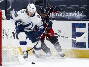 Tampa Bay Lightning defenseman Mikhail Sergachev skates for the puck against Columbus Blue Jackets right wing Cam Atkinson in the first period at Nationwide Arena.