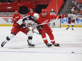 Columbus Blue Jackets center Boone Jenner (38) and Detroit Red Wings right wing Anthony Mantha (39) battle for the puck during the third period at Little Caesars Arena on Monday.