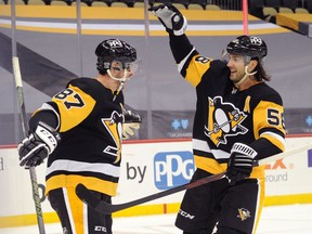 Pittsburgh Penguins center Sidney Crosby celebrates his game winning goal in overtime with defenseman Kris Letang against the Washington Capitals at PPG Paints Arena.