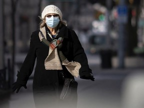 A pedestrian wears a mask while walking along Ouellette Avenue in downtown Windsor, Wednesday, January 13, 2020.