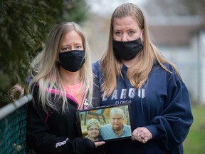 Melanie Baillargeon-Reeves (left) and Shelley Reeves (right) hold a photo of their parents, Richard and Lynda Reeves of Windsor. The couple died of COVID-19 from Dec. 18 and Dec. 20, 2020.