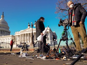 Members of the news media survey damaged equipment outside the U.S. Capitol a day after supporters of U.S. President Donald Trump occupied the Capitol in Washington, U.S., January 7, 2021.