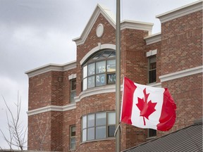 A Canadian flag flies at half mast outside The Village at St. Clair long-term care home on Friday, where 151 residents and 106 staff members have tested positive for COVID-19.