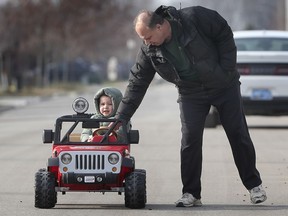 Julian Trombley gets a bit of directional help from his grandfather Rick Cian during a sunny day on Wednesday, January 13, 2021, on Donlon Street in LaSalle, ON.