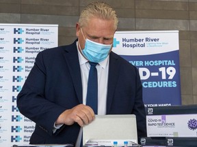 Ontario Premier Doug Ford examines COVID-19 Rapid Test Device kits at Humber River Hospital in Toronto on November 24, 2020. THE CANADIAN PRESS/Frank Gunn ORG XMIT: fng101