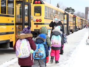 St. John Vianney Catholic Elementary School students head to school buses following their first day returning to in-school classes Monday, Feb. 8.