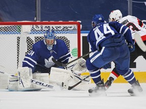 Evgenii Dadonov of the Ottawa Senators scores the game-winning goal under pressure from Maple Leafs' Morgan Rielly as goaltender Frederik Andersen tries to stop him during overtime during at Scotiabank Arena on Monday, Feb. 15, 2021 in Toronto.