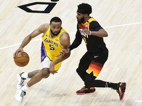 Talen Horton-Tucker of the Los Angeles Lakers drives into Mike Conley of the Utah Jazz during a game at Vivint Smart Home Arena on February 24, 2021 in Salt Lake City, Utah.