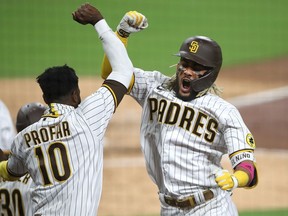 Jurickson Profar congratulates Fernando Tatis Jr. of the San Diego Padres after his two-run homerun during the seventh inning of Game Two of the National League Wild Card Series against the St. Louis Cardinals at PETCO Park on October 01, 2020 in San Diego, California.