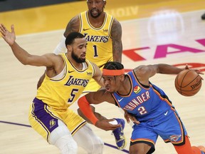 Shai Gilgeous-Alexander of the Oklahoma City Thunder drives against Talen Horton-Tucker of the Los Angeles Lakers at Staples Center on February 08, 2021 in Los Angeles, California.