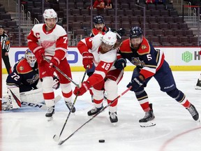 Marc Staal of the Detroit Red Wings battles for the puck against Aaron Ekblad #5 of the Florida Panthers during the second period at Little Caesars Arena on February 20, 2021 in Detroit, Michigan.