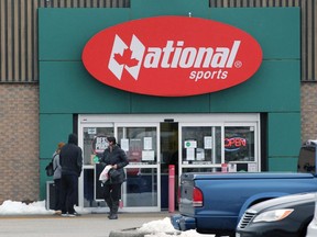 Customers lineup outside National Sports Tecumseh in the St. Clair Beach Plaza on Monday.