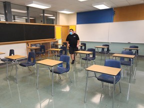 Local classroom learning resumes on Monday. Shown here on Aug. 25, 2020, custodian Tom Rajic helps set up a secondary school classroom at W. F. Herman Academy ahead of the fall semester.
