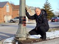 Southwood Lakes resident John Chisholm, who started a petition that has attracted more than 500 neighbourhood signatures, shows one of the damaged ornamental light standards on Tuesday, Feb. 2, 2021.