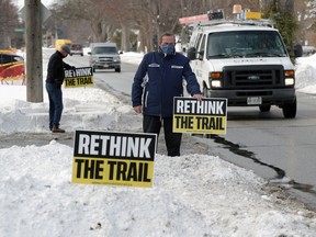 Tecumseh resident John Parent shows lawn signs promoting ReThink The Trail - a citizen movement opposed to extending the Ganatchio Trail along Riverside Drive in Tecumseh. Photographed Feb. 16, 2021.