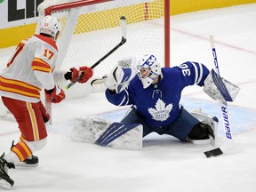 Maple Leafs goalie Micheal Hutchinson makes a glove save in front of Calgary Flames forward Milan Lucic during the second period at Scotiabank Arena on Monday, Feb. 22, 2021.