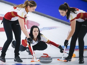 Team Canada skip Kerri Einarson, centre, makes a shot against Team Northern Ontario as lead Briane Meilleur, right, and second Shannon Birchard sweep at the Scotties Tournament of Hearts in Calgary, Alta., Sunday, Feb. 21, 2021.