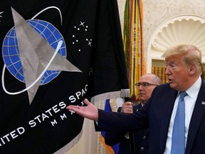 U.S. President Donald Trump gestures towards the U.S. Space Force flag during a presentation of the flag in the Oval Office of the White House in Washington, D.C., May 15, 2020.
