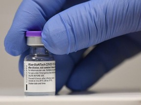 In this file photo taken on Dec. 8, 2020, a member of staff poses with a phial of Pfizer-BioNTech Covid-19 vaccine at a vaccination health centre in Cardiff, South Wales.