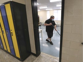 Getting ready for the big return to school. Cory Gagnon, a custodian at Kennedy Collegiate, cleans a classroom at the Windsor secondary school on Friday, Feb. 5, 2021, in anticipation of students returning Monday.