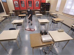 Cory Gagnon, a custodian at Kennedy Collegiate, cleans a classroom in anticipation of students returning Monday.