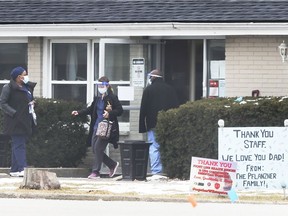 Staff are shown at the main entrance to the Banwell Gardens long-term care home in Windsor on Feb. 4, 2021.