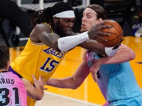 Los Angeles Lakers center Montrezl Harrell drives to the basket between Miami Heat guard Max Strus and Miami Heat forward Kelly Olynyk during the third quarter at Staples Center.