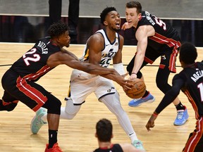 Utah Jazz guard Donovan Mitchell is fouled by Miami Heat guard Duncan Robinson as Miami Heat forward Jimmy Butler follows on the play in the fourth quarter at American Airlines Arena.