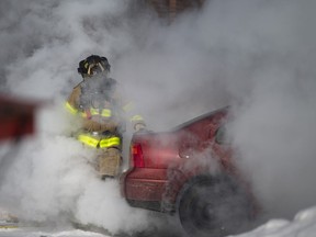 Surrounded by smoke and steam, a Windsor Fire and Rescue Services firefighter responds to a Volkswagen Jetta on fire in the parking lot behind Taloola Cafe in Walkerville, Friday, Feb. 19, 2021.