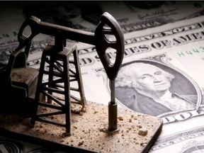 A 3D printed oil pump jack is placed on dollar banknotes in this illustration picture, April 14, 2020.