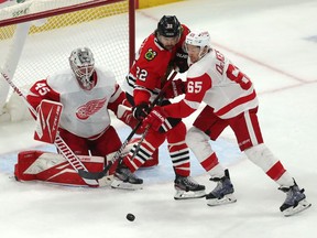 Chicago Blackhawks center Ryan Carpenter and Detroit Red Wings defenseman Danny DeKeyser fight for the puck in front of goaltender Jonathan Bernier during the third period at the