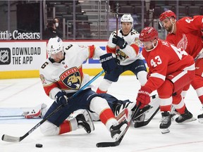 Florida Panthers defenseman Anton Stralman clears the puck as Detroit Red Wings left wing Darren Helm applies pressure during the second period at Little Caesars Arena.