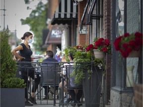 Expanded sidewalk cafe opportunities in Windsor's urban core last year not only helped struggling businesses but generated an urban buzz. Shown June 25, 2020, a waitress works on the patio at Vito's Pizzeria in Old Walkerville on the first day of patios reopening since the COVID-19 pandemic began.