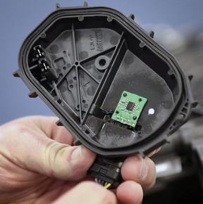 Nick Dimitrov, vice-president of sales and applications at AIS Technologies in Windsor, shows a circuit board with tiny semiconductors on Friday.