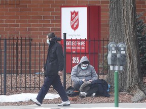 People are shown in front of the Salvation Army building on Church Street, the site of a COVID-19 outbreak, on Wednesday, February 24, 2021.