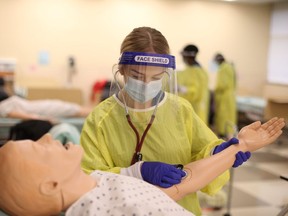 Taylor Iftiniuk, a student in St. Clair College's personal support worker program, trains on a medical manikin Thursday.