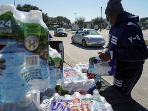 Harris County workers carry water bottles to hand to those who are in need after winter weather caused food and clean water shortage in Houston, Texas, U.S. February 19, 2021.