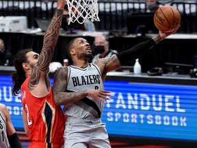 Damian Lillard of the Portland Trail Blazers drives to the basket on Steven Adams of the New Orleans Pelicans during the second half at Moda Center on March 16, 2021 in Portland, Oregon. Blazers won 125-124.