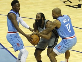 James Harden of the Brooklyn Nets is pressured by P.J. Tucker of the Houston Rockets and Victor Oladipo at Toyota Center on March 03, 2021 in Houston, Texas.