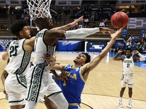 Joshua Langford of the Michigan State Spartans and Malik Hall attempt to block the layup by Jules Bernard of the UCLA Bruins during overtime in the First Four game prior to the NCAA Men's Basketball Tournament at Mackey Arena on March 18, 2021 in West Lafayette, Indiana.