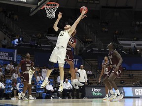 Austin Davis of the Michigan Wolverines has his shot defended by John Walker III of the Texas Southern Tigers during the second half in the first round game of the 2021 NCAA Men's Basketball Tournament at Mackey Arena on March 20, 2021 in West Lafayette, Indiana.