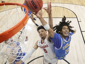 Tyger Campbell of the UCLA Bruins battles with Jaden Shackelford of the Alabama Crimson Tide during overtime in the Sweet Sixteen round game of the 2021 NCAA Men's Basketball Tournament at Hinkle Fieldhouse on March 28, 2021 in Indianapolis, Indiana.