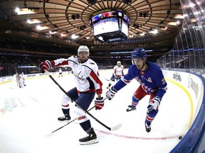 Brenden Dillon of the Washington Capitals skates against Chris Kreider of the New York Rangers during their game at Madison Square Garden on March 30, 2021 in New York City.